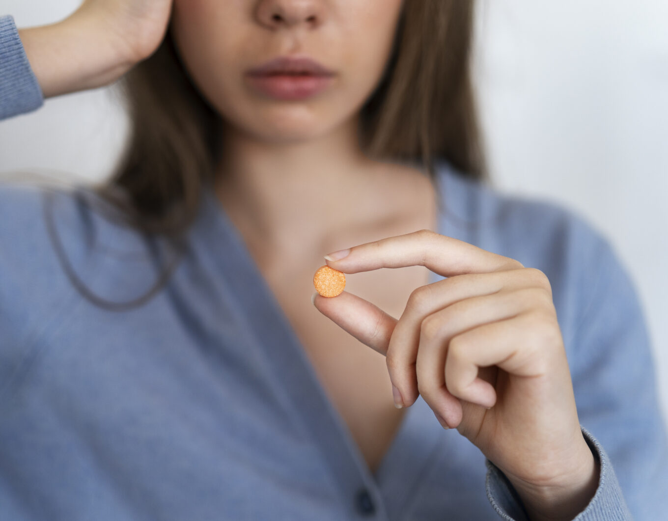 front view woman holding pill - 헤어온의원